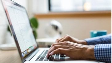 A business person’s hands typing on a computer keypad