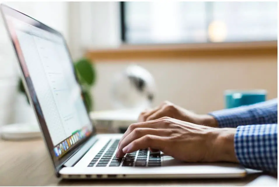 A business person’s hands typing on a computer keypad