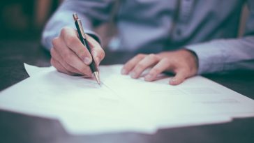 Man writing business letter on paper